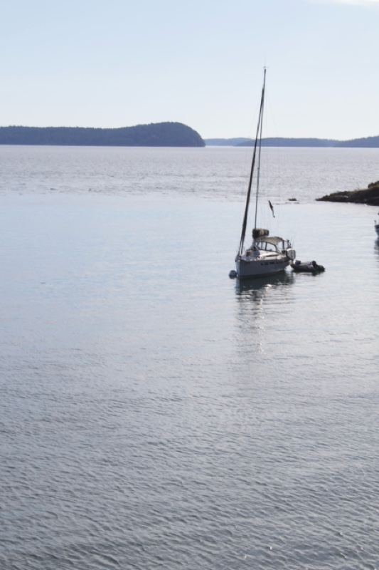 Sailboat on Calm Water with Distant Island