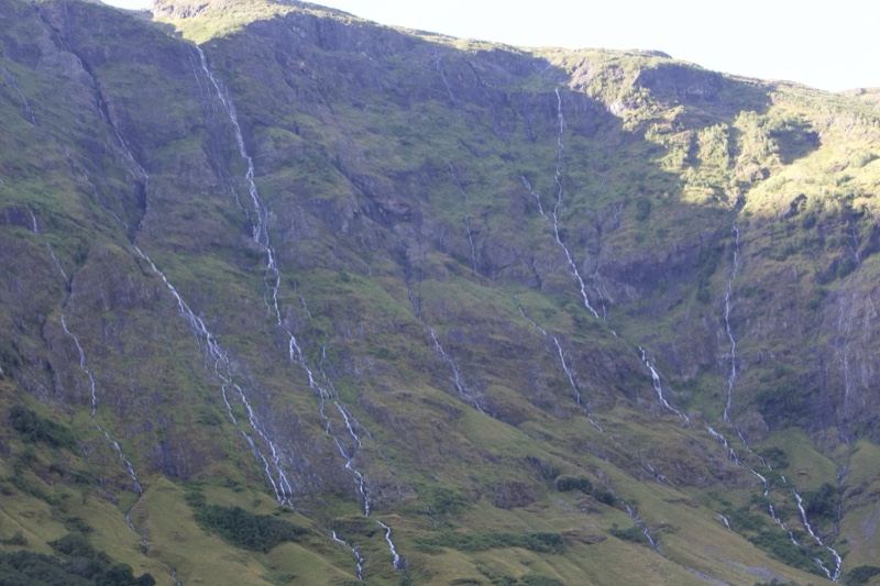 Mountain Cascades on Green Hillside