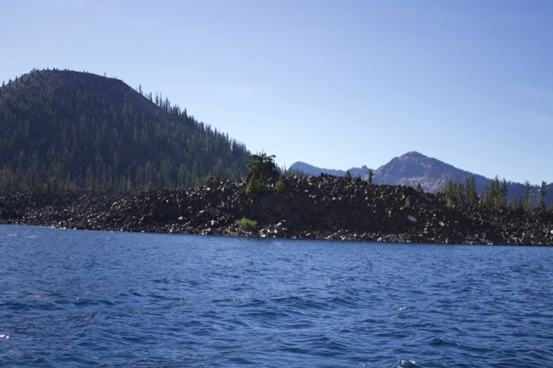 Lake with volcanic shoreline and mountains