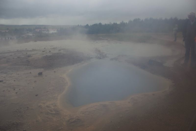 Steaming Geothermal Pool in Misty Landscape