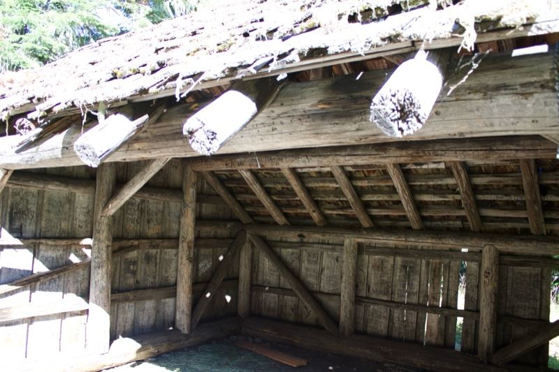 Weathered wooden eave with hanging cylinders