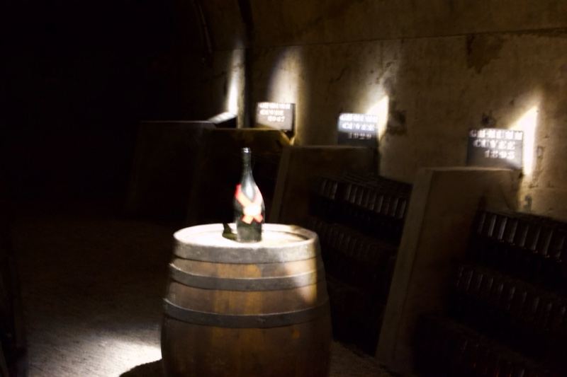 Wine Bottle on Barrel in Dim Cellar