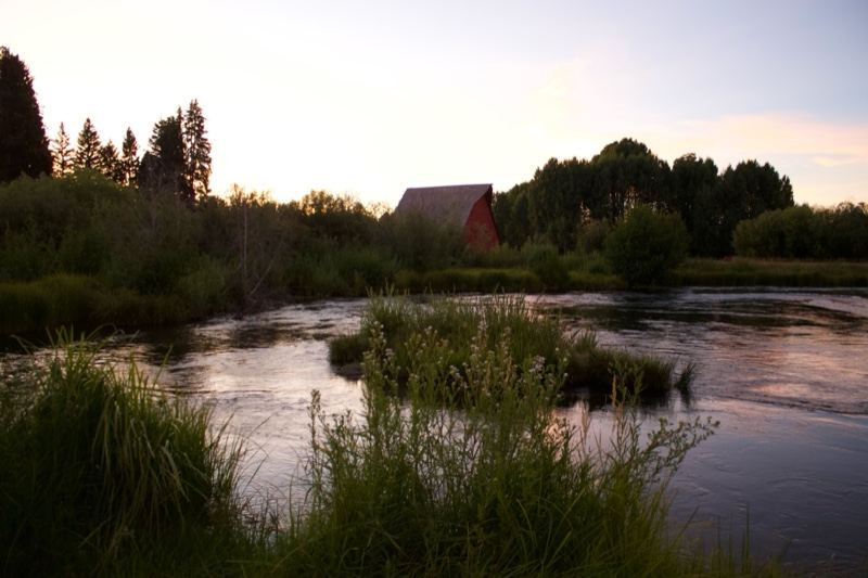 River at dusk with red barn