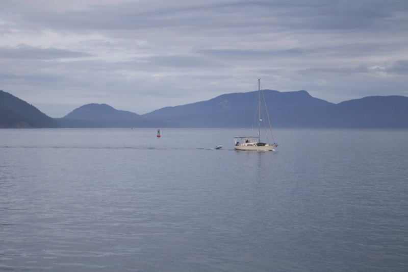 Sailboat on Calm Water with Mountains