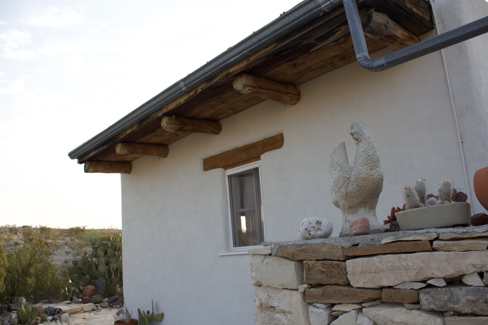 White Adobe House with Rooster Statue