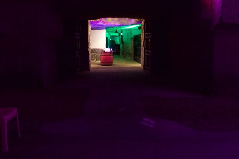 Dim tunnel leading to lit chamber