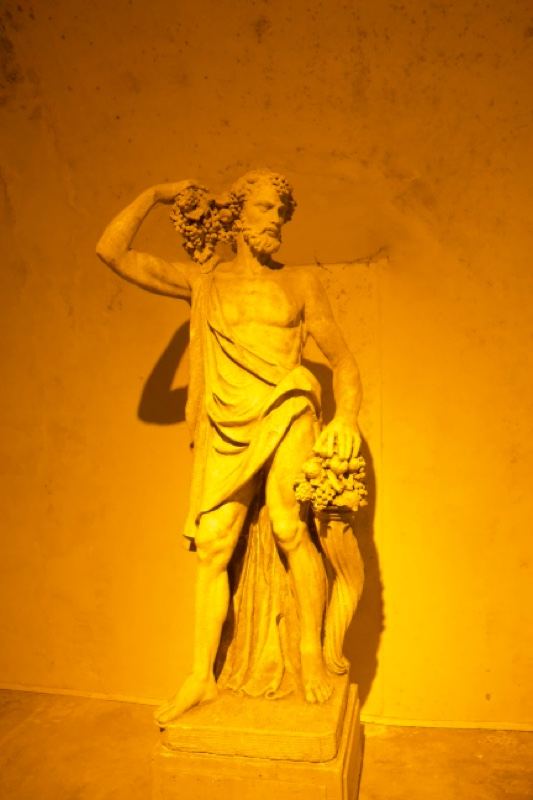 Yellow-lit Bacchus statue indoors