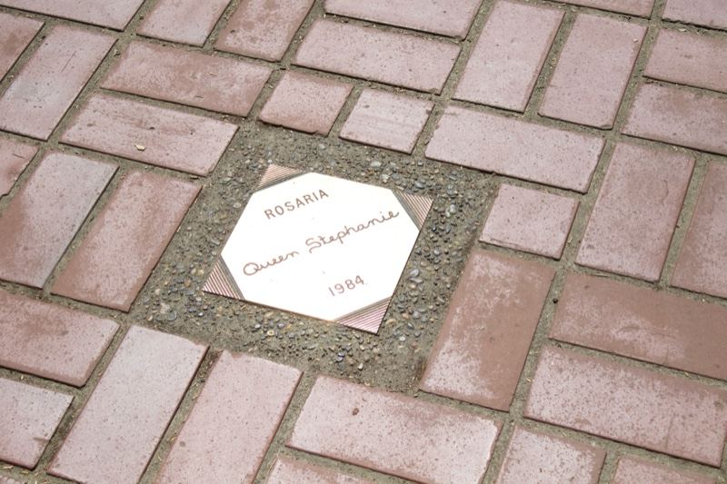 Hexagonal memorial plaque on brick pavement