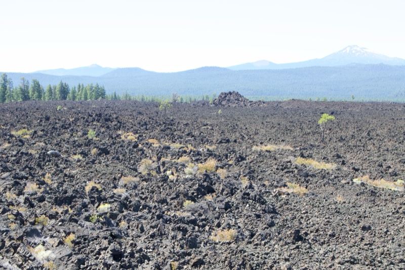 Volcanic Lava Field With Distant Mountains