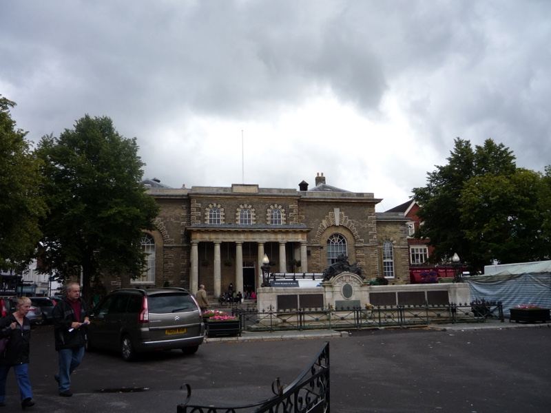 Historic stone guildhall under cloudy sky