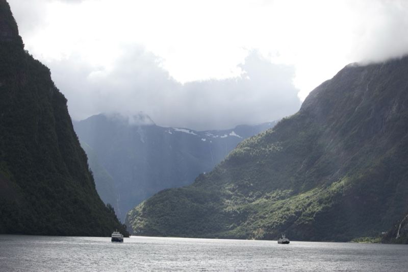 Fjord Mountains With Boats Under Clouds