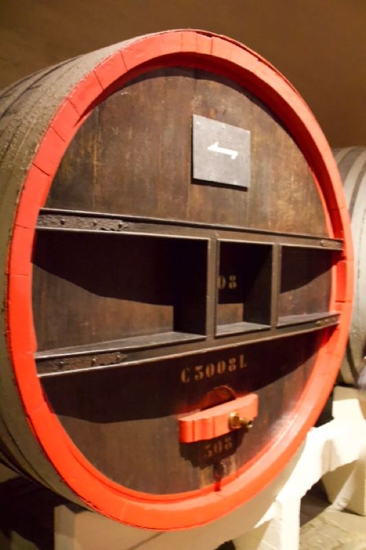 Large wooden wine barrel with red hoop
