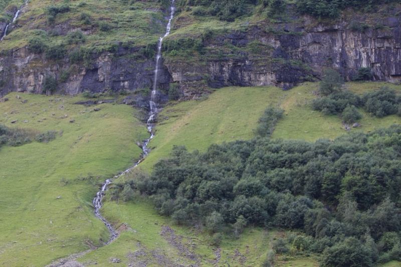 Waterfall Cascading Down Green Hillside