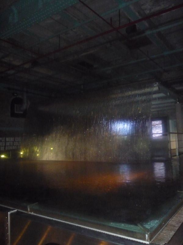 Indoor waterfall exhibit in dim hall