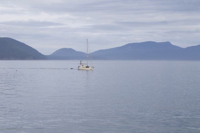 Sailboat on Calm Water with Mountains