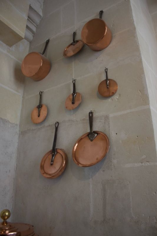 Copper Pans Hanging on Stone Wall