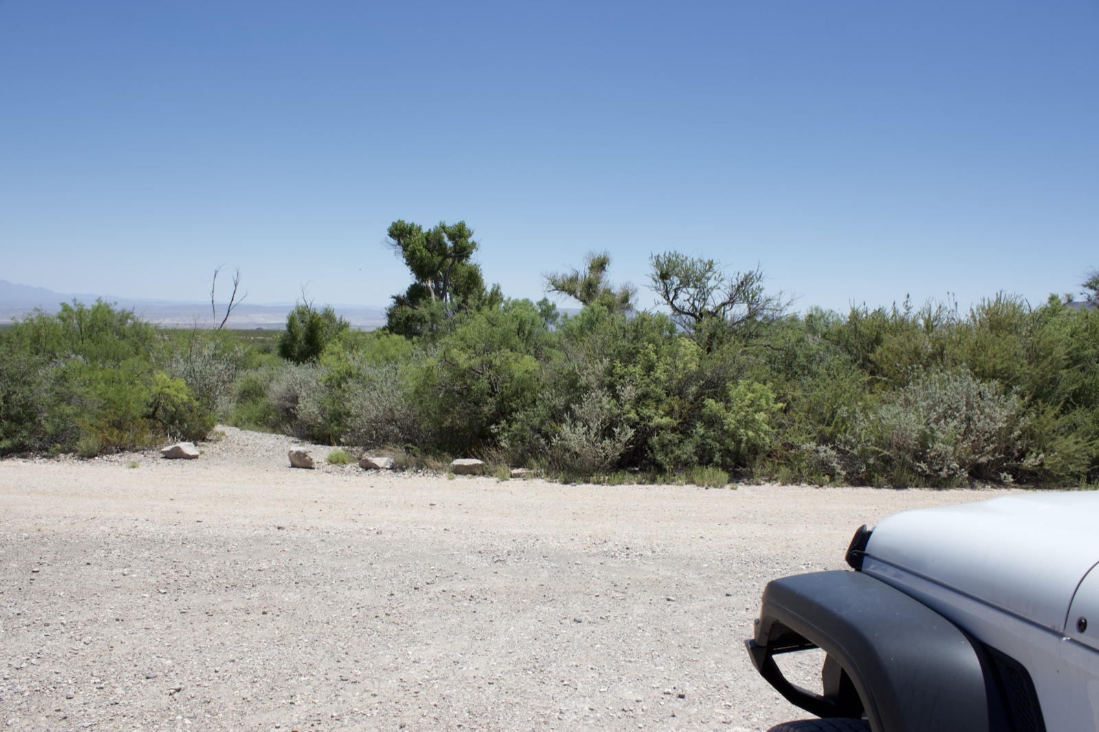Desert gravel road with white jeep