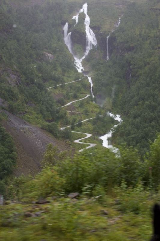 Misty Waterfall Cascading Down Forested Valley