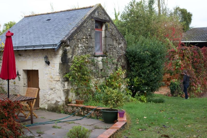 Stone cottage garden with red umbrella
