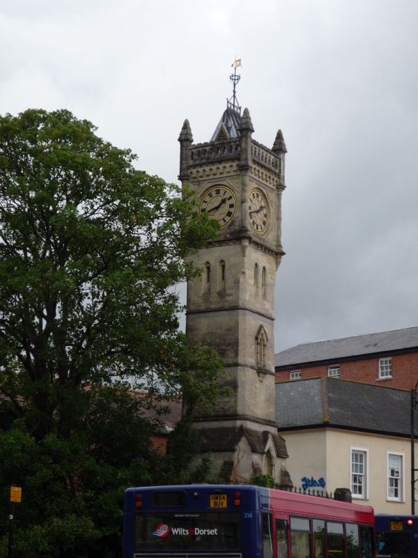 Stone clock tower with bus below