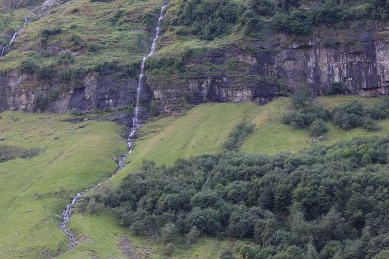 Waterfall Cascading Down Grassy Cliff