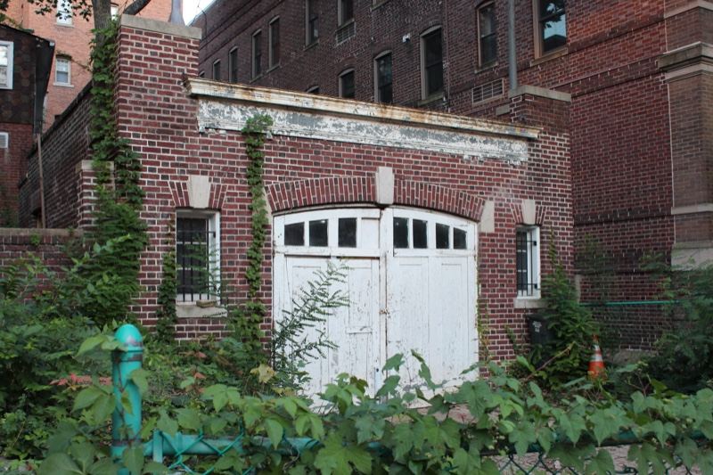Overgrown Brick Building With White Door