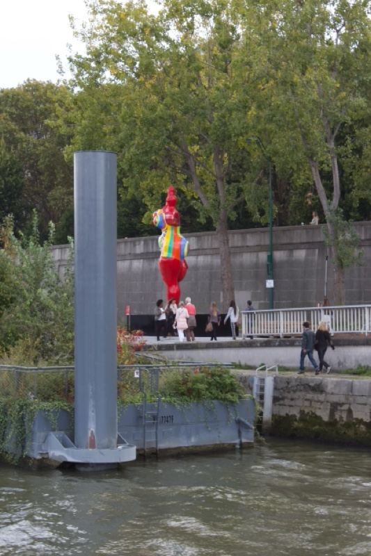 Colorful rooster sculpture by river