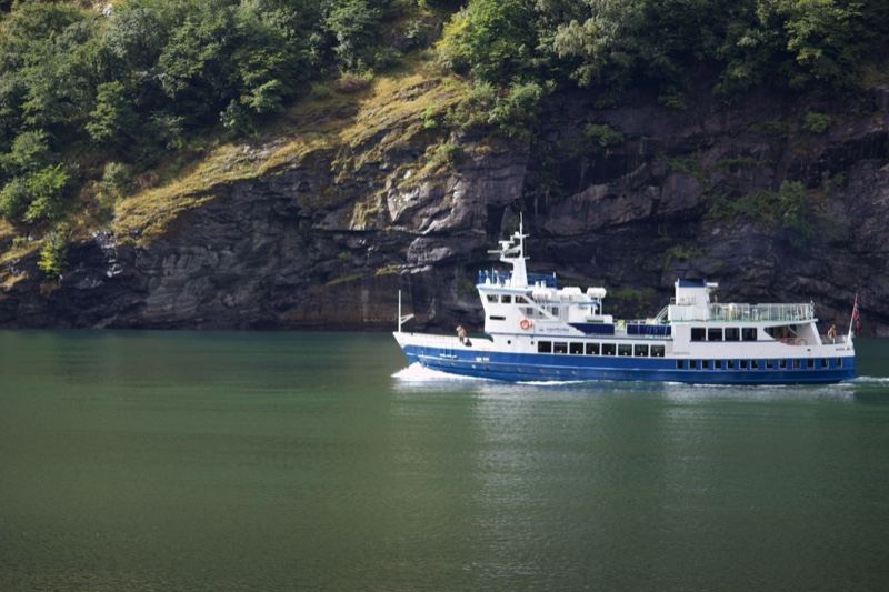 Ferry Cruising Fjord Near Rocky Cliffs