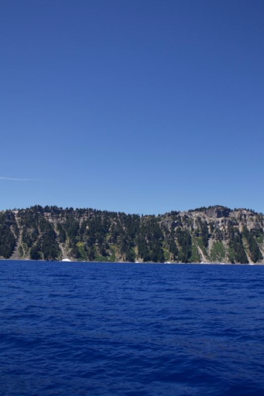 Deep Blue Lake With Forested Cliffs