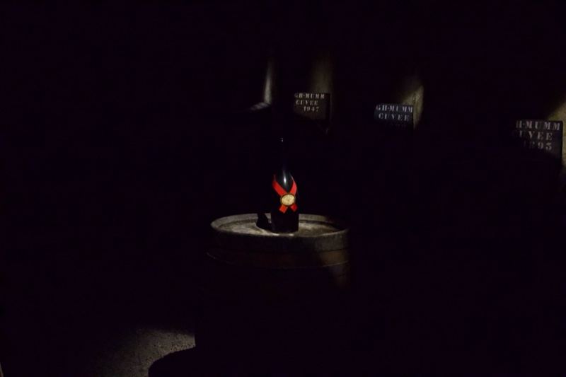 Lit Bottle on Barrel in Dark Room