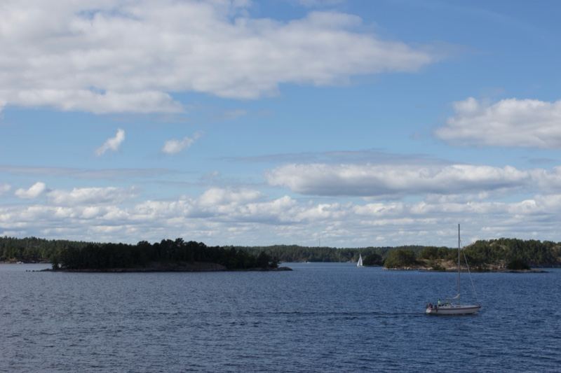 Lake Archipelago with Sailboat Under Clouds