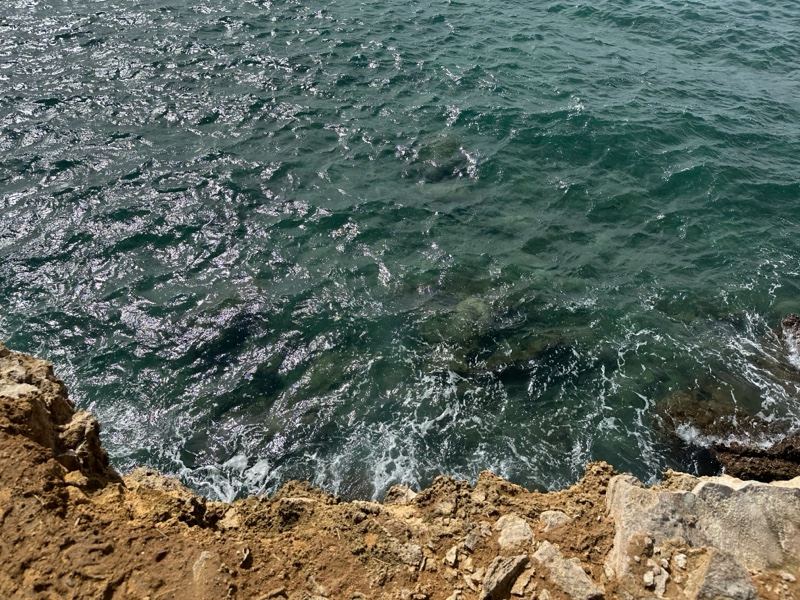 Turquoise Sea Against Rocky Cliff Edge