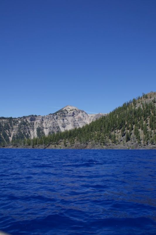 Deep blue lake with forested mountain