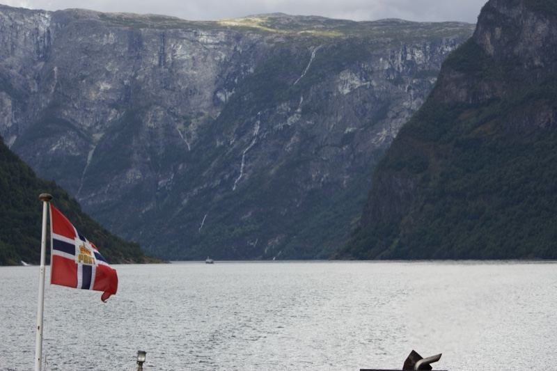 Norwegian Flag Over Fjord Mountains