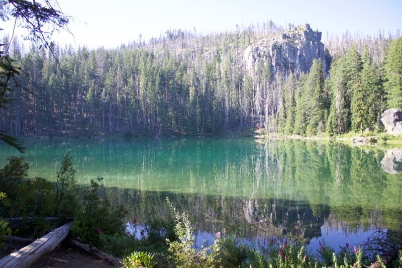 Alpine Lake Reflecting Forested Mountains