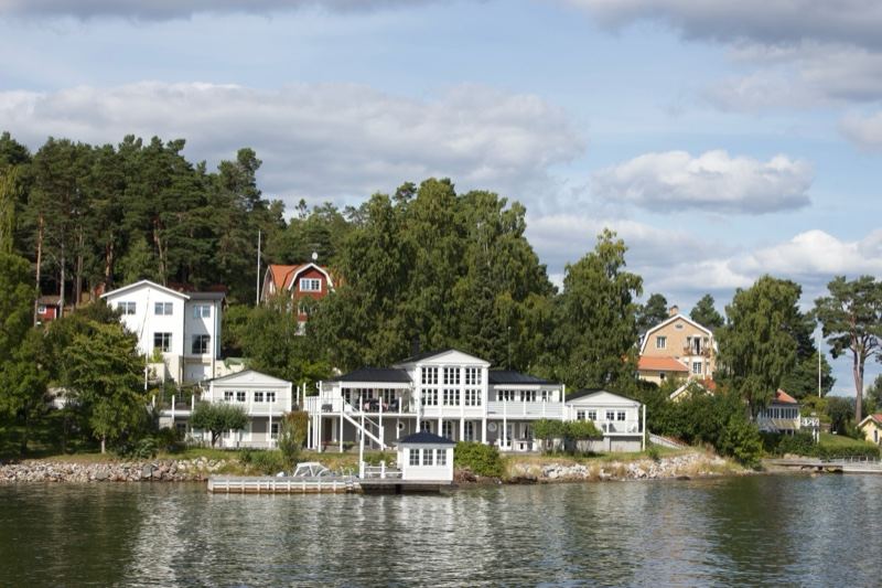Lakefront Houses Under Cloudy Sky