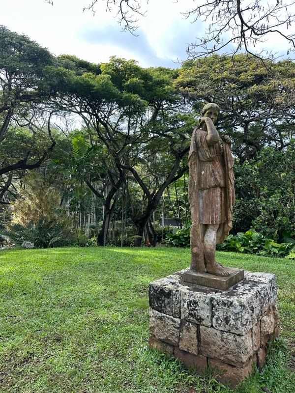 Weathered Statue in Lush Garden