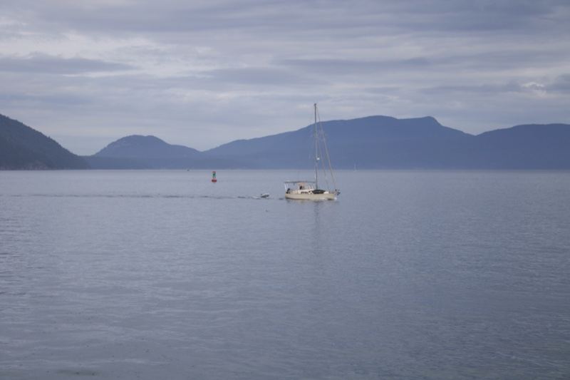 Sailboat on Calm Water with Mountains