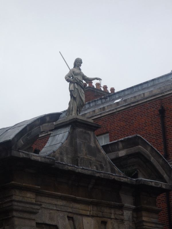 Statue atop historic building roof