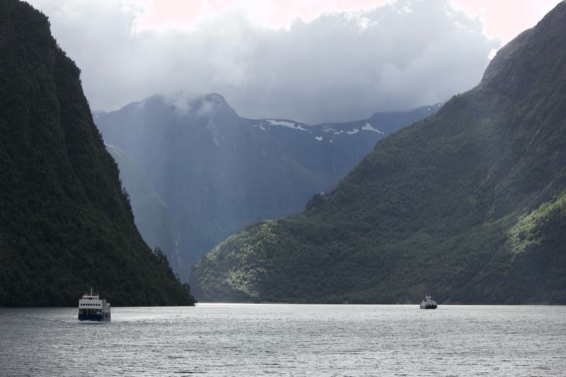 Fjord Mountains With Boats Under Cloudy Sky