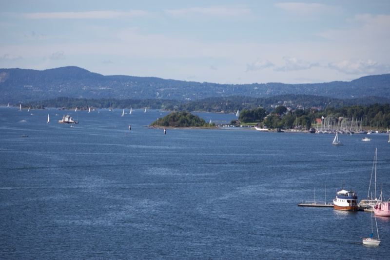 Coastal Fjord With Sailboats And Mountains