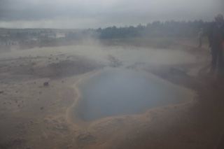 Steaming Geothermal Pool in Misty Landscape