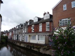Terraced Houses Along Canal Under Clouds