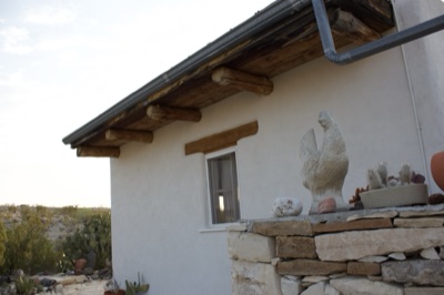White Adobe House with Rooster Statue