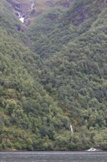 Forested Mountains With Waterfalls Over Fjord
