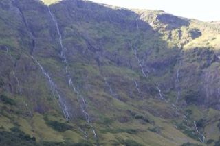 Mountain Cascades on Sunlit Slope