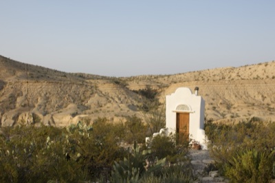 White adobe chapel in desert landscape