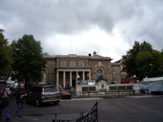 Historic stone guildhall under cloudy sky
