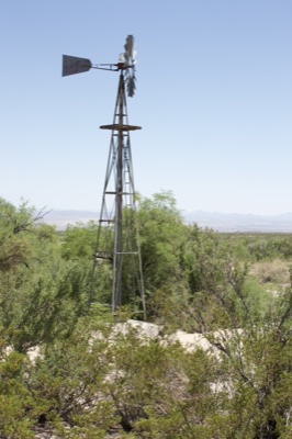 Windmill in Desert Scrub Landscape