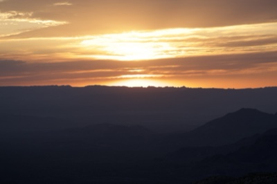 Sunset Over Layered Mountain Silhouettes